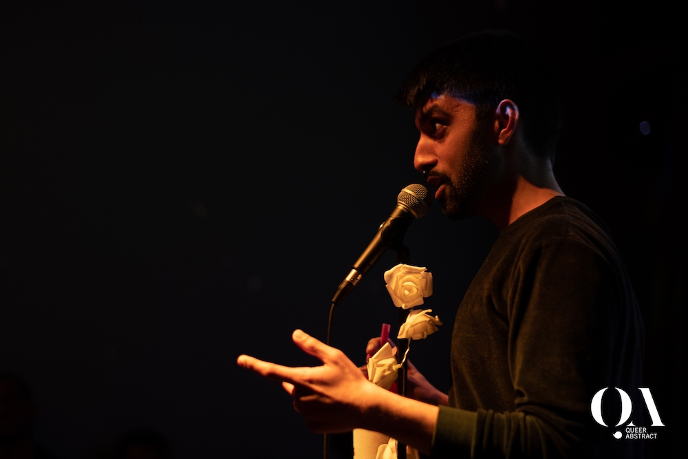 Very dark black image with Anooj speaking into a mic